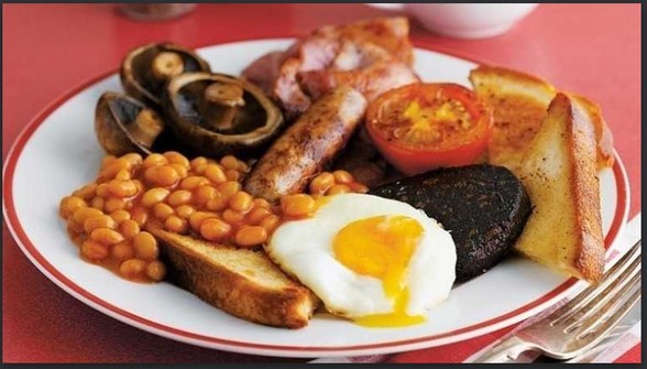 Photograph of a full English breakfast: Sausage, baked beans, mushrooms, fried egg, bacon, toast, tomato