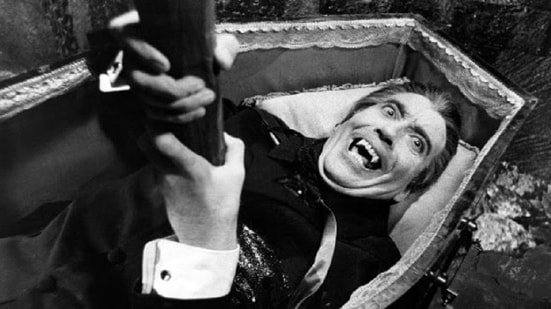 Black and white picture of a man with vampire teeth in a coffin clutching at a stake driven through his heart. A metaphor for a dead Brexit