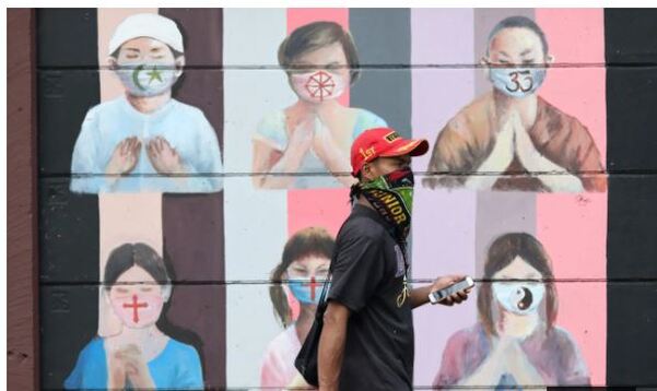 Mural of Indonesian children of a variety of faiths, each wearing a mask with a symbol of their faith, praying.