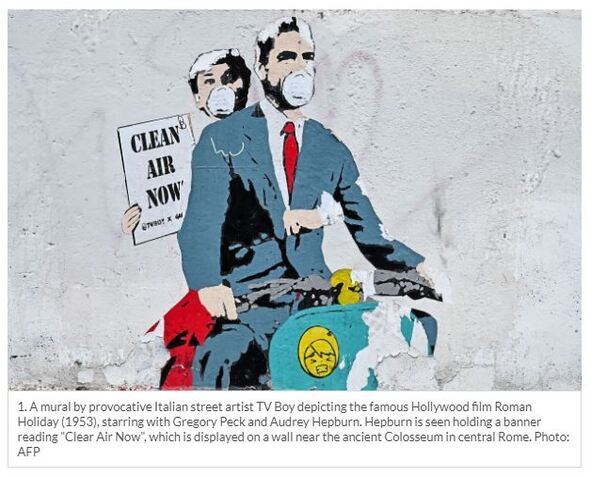 Mural in Rome showing Audrey Hepburn and Gregory peck on a motor bike, wearing Covid-19 face masks. Hepburn is hold a placard asking for 